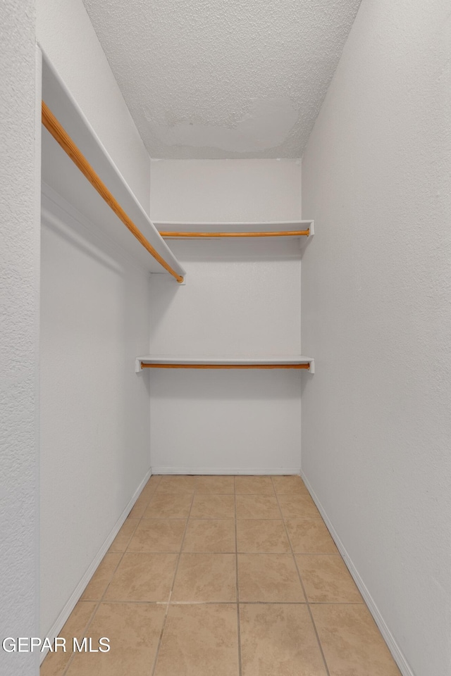 spacious closet featuring light tile patterned floors