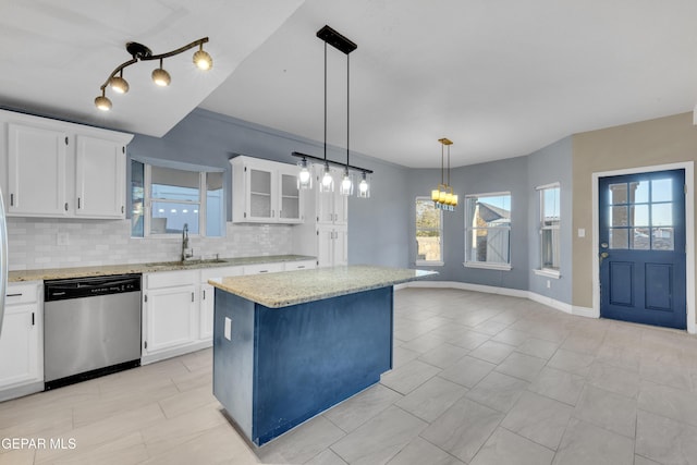 kitchen featuring backsplash, white cabinets, stainless steel dishwasher, and a kitchen island