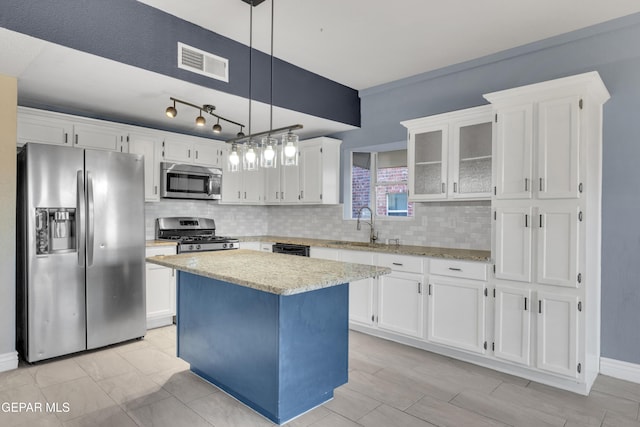 kitchen featuring white cabinetry, hanging light fixtures, a center island, and stainless steel appliances