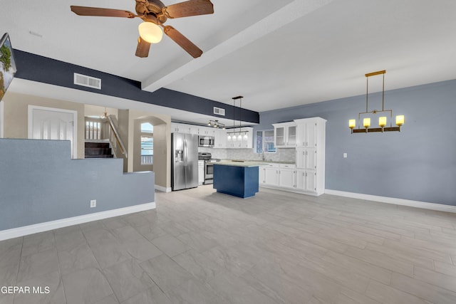 unfurnished living room featuring beamed ceiling, ceiling fan, and sink