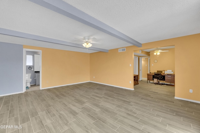 unfurnished living room with a textured ceiling, ceiling fan, light hardwood / wood-style floors, and beam ceiling