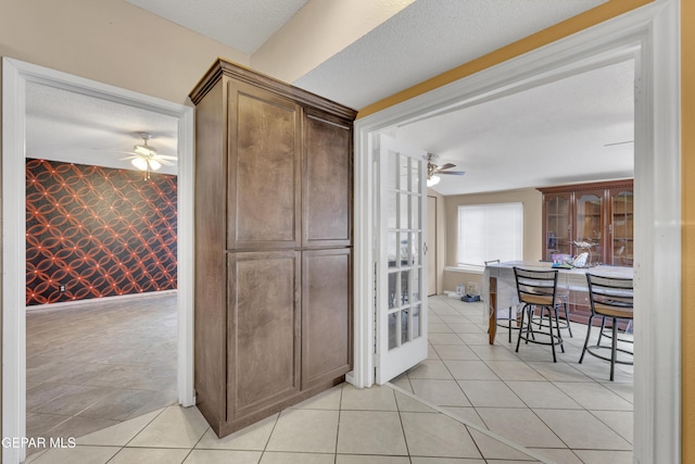 kitchen with ceiling fan, light tile patterned floors, and a textured ceiling