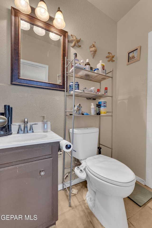 bathroom featuring tile patterned flooring, vanity, and toilet