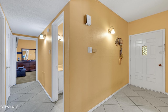 foyer entrance with light tile patterned floors and a textured ceiling