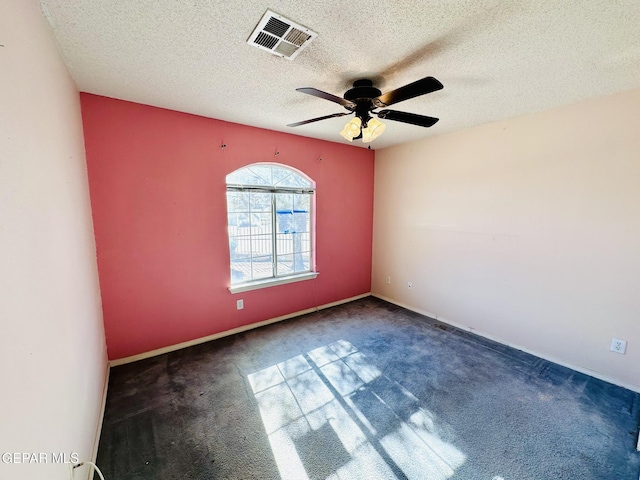 unfurnished room featuring dark colored carpet, ceiling fan, and a textured ceiling