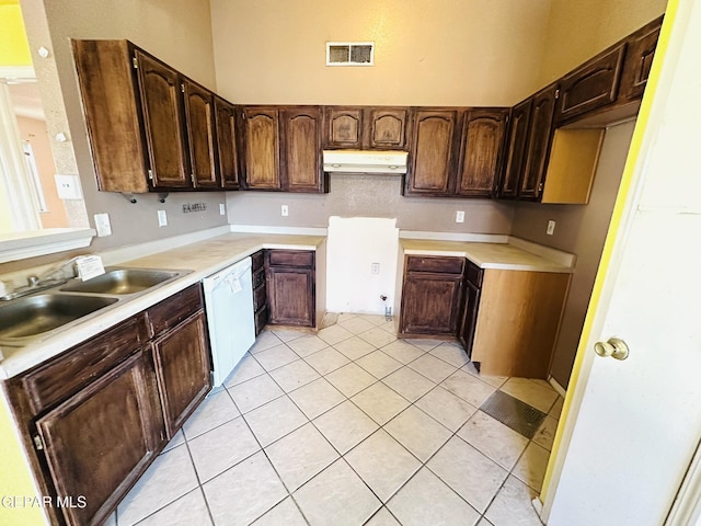 kitchen with light tile patterned flooring, white dishwasher, and sink