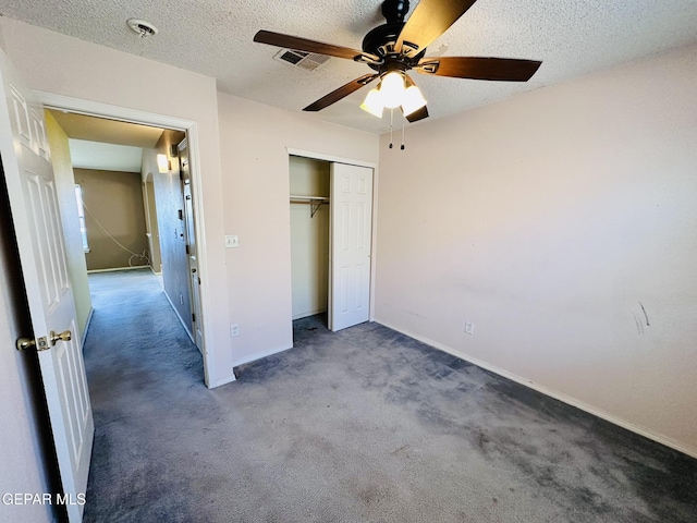 unfurnished bedroom with carpet, ceiling fan, a textured ceiling, and a closet