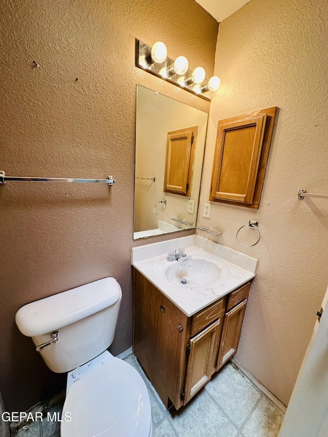 bathroom featuring tile patterned flooring, vanity, and toilet