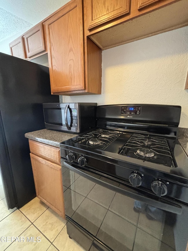 kitchen featuring gas stove and light tile patterned floors