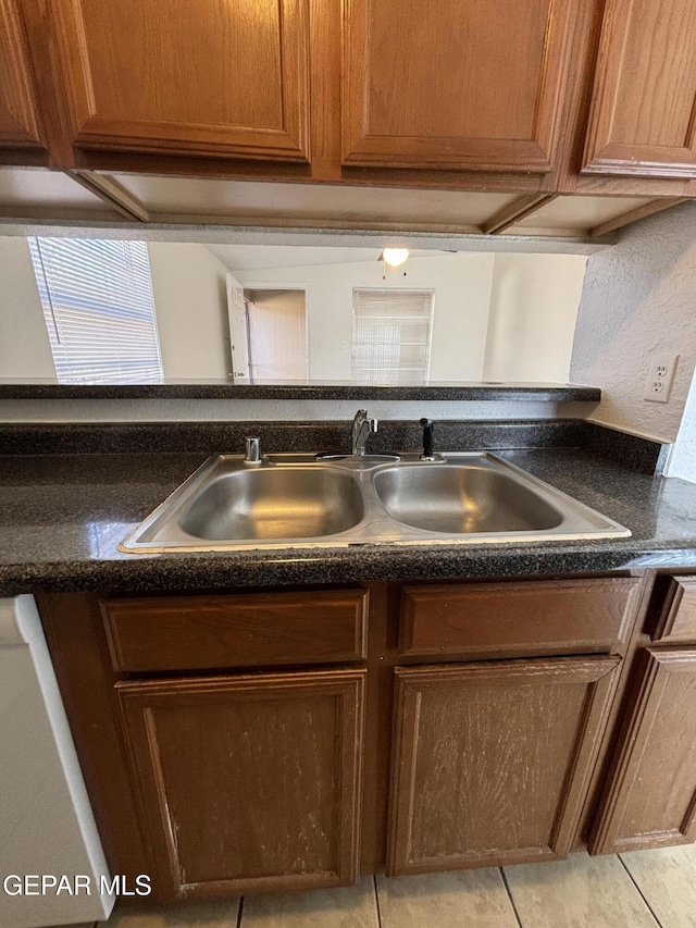 kitchen with dishwasher, sink, and light tile patterned flooring