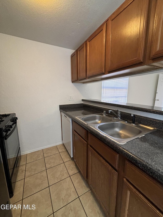 kitchen featuring dishwasher, black range oven, sink, a textured ceiling, and light tile patterned flooring