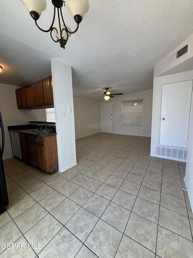 kitchen featuring ceiling fan with notable chandelier, a textured ceiling, sink, decorative light fixtures, and light tile patterned flooring