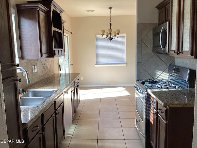 kitchen with decorative backsplash, stainless steel appliances, sink, light tile patterned floors, and an inviting chandelier