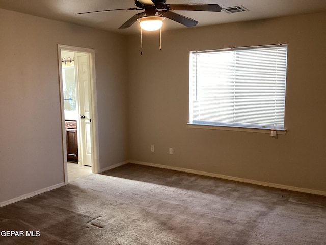 carpeted spare room with ceiling fan