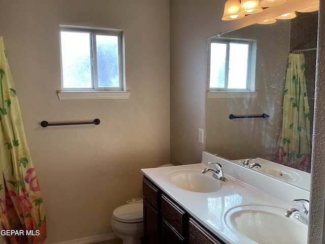 bathroom with a shower with curtain, vanity, toilet, and a wealth of natural light