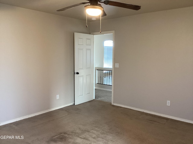 carpeted spare room with ceiling fan