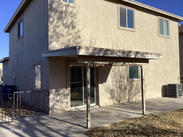 rear view of property featuring cooling unit and a patio area