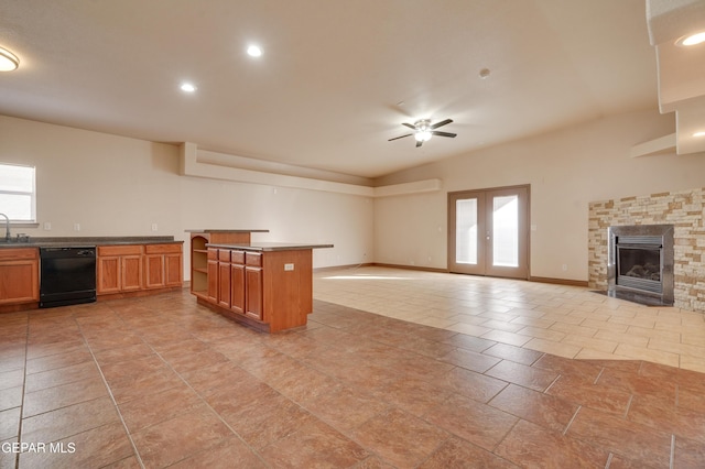 kitchen with a fireplace, a center island, black dishwasher, french doors, and ceiling fan