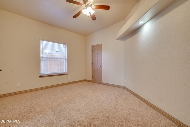 unfurnished room with ceiling fan and carpet