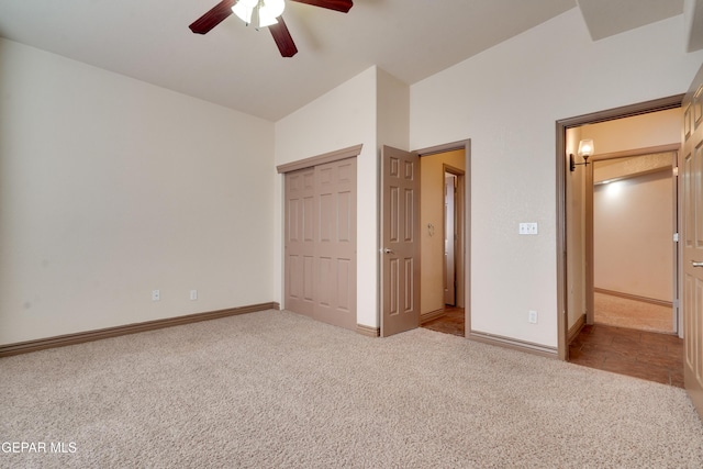 unfurnished bedroom featuring lofted ceiling, ceiling fan, a closet, and light carpet