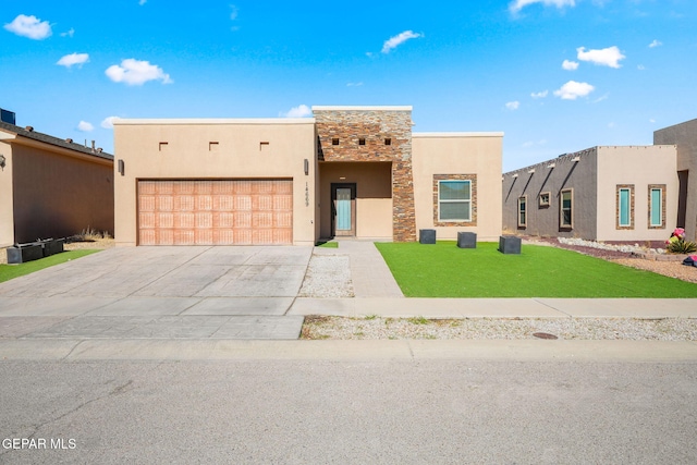 pueblo revival-style home featuring a front yard and a garage