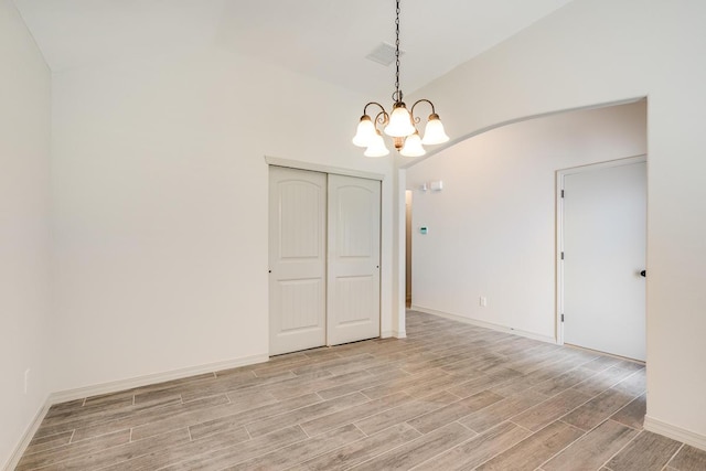 13820 Madero Ave, El Paso, TX 79928 - empty room with lofted ceiling, a chandelier, light wood-style flooring, and baseboards