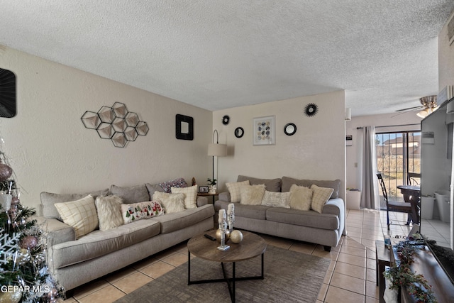 living room with ceiling fan, light tile patterned floors, and a textured ceiling