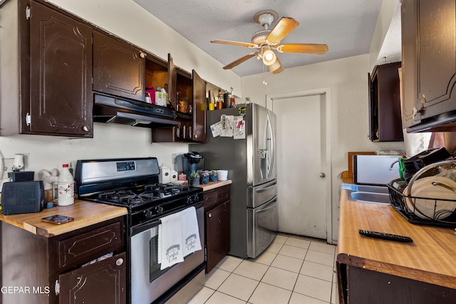 kitchen featuring ceiling fan, gas range oven, a textured ceiling, range hood, and light tile patterned flooring