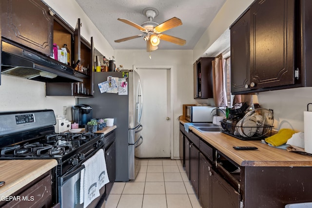 kitchen featuring black gas range, ceiling fan, sink, dark brown cabinets, and light tile patterned flooring