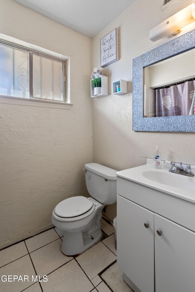 bathroom with tile patterned flooring, vanity, and toilet