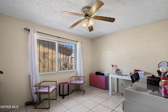 tiled home office with ceiling fan and a textured ceiling