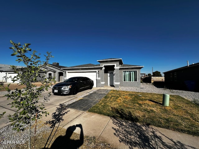 view of front of house featuring a garage and a front lawn