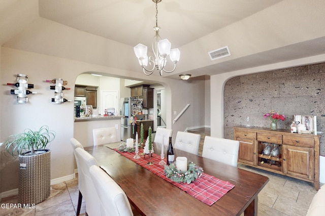 tiled dining space featuring a chandelier