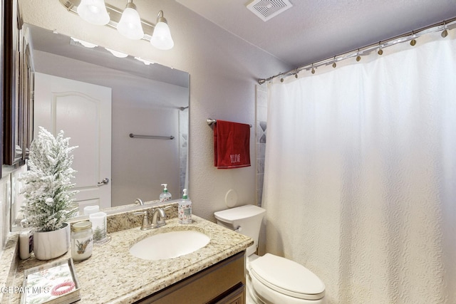 bathroom featuring walk in shower, vanity, a textured ceiling, and toilet