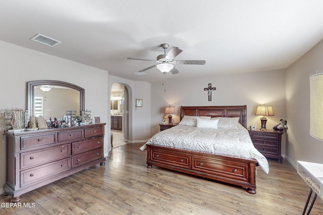 bedroom featuring light wood-type flooring, connected bathroom, and ceiling fan