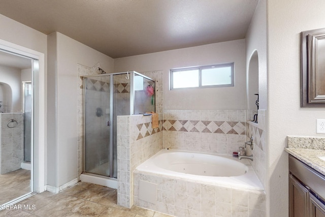 bathroom featuring a textured ceiling, vanity, and separate shower and tub