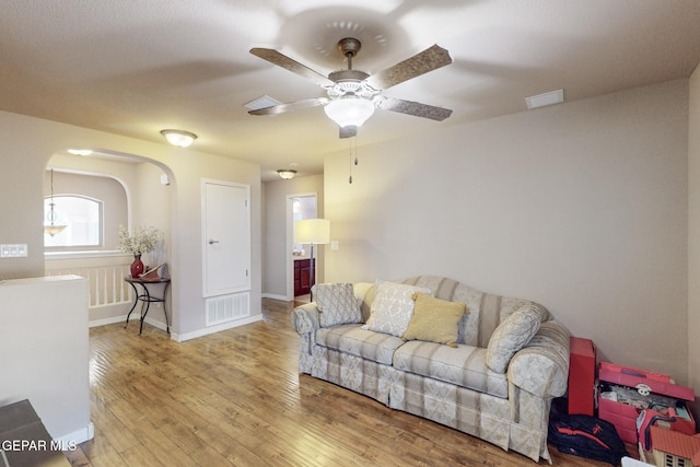 living room with ceiling fan and wood-type flooring