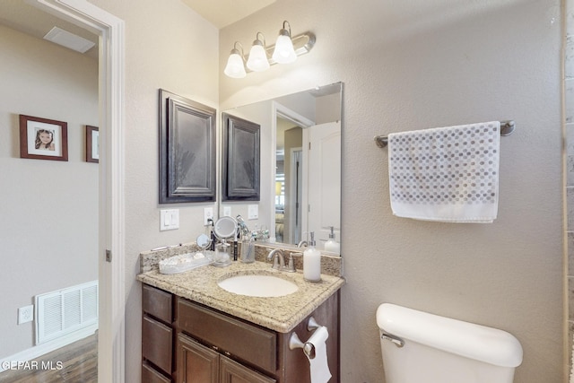 bathroom featuring vanity, wood-type flooring, and toilet