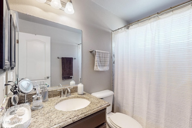 bathroom featuring a shower with curtain, vanity, and toilet