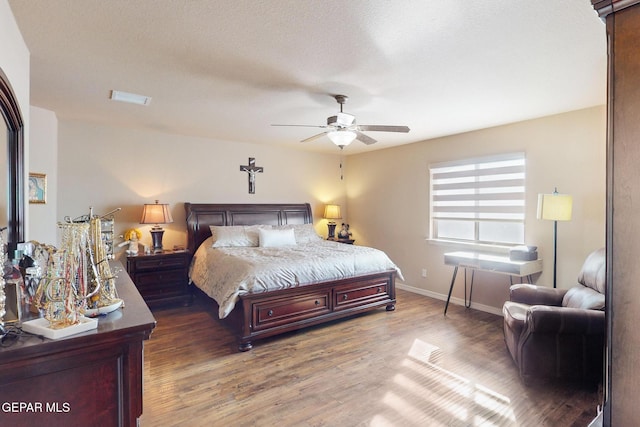 bedroom with ceiling fan, dark hardwood / wood-style flooring, and a textured ceiling