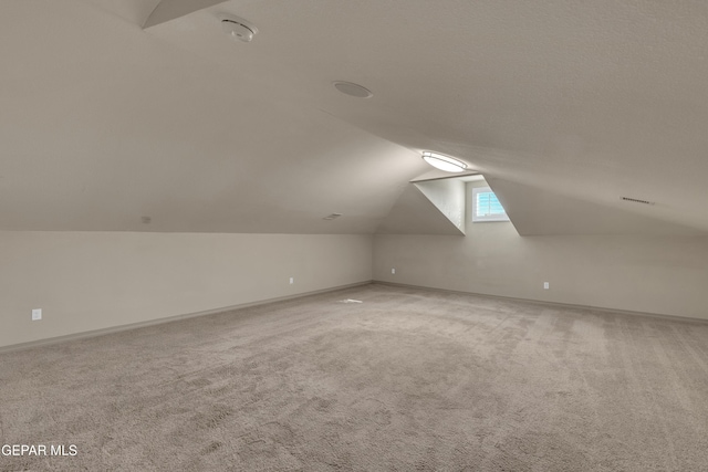 additional living space featuring carpet and lofted ceiling