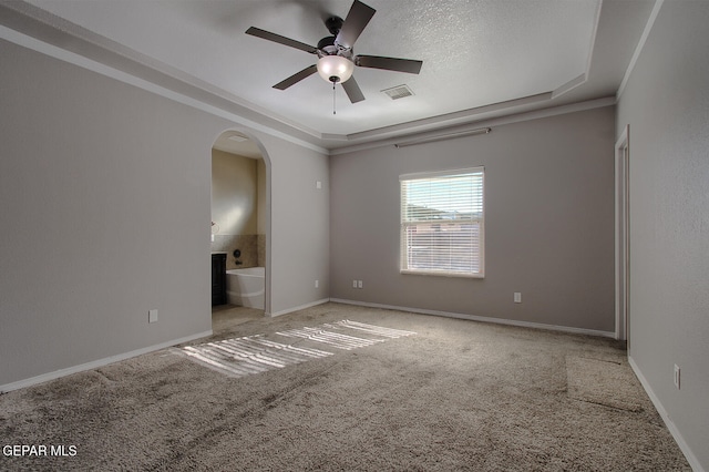 carpeted spare room featuring a textured ceiling, a raised ceiling, ceiling fan, and crown molding