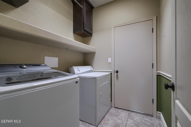 washroom with cabinets, light tile patterned floors, and washer and dryer