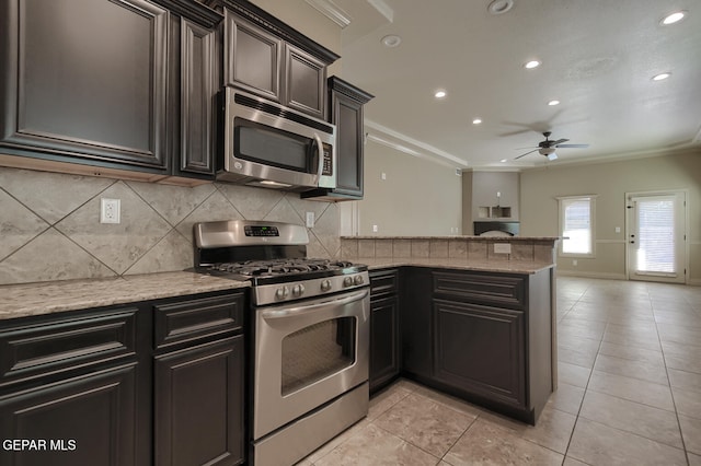 kitchen with backsplash, ornamental molding, stainless steel appliances, ceiling fan, and light tile patterned floors