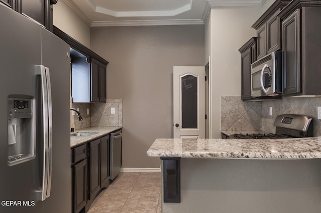 kitchen with light stone countertops, appliances with stainless steel finishes, tasteful backsplash, and sink