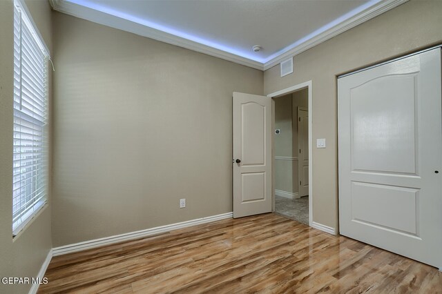 unfurnished bedroom with light hardwood / wood-style floors and ornamental molding