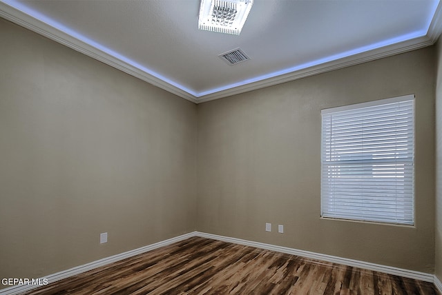 spare room featuring dark hardwood / wood-style floors and ornamental molding