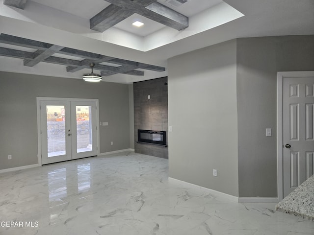 unfurnished living room featuring coffered ceiling, a fireplace, beamed ceiling, and french doors