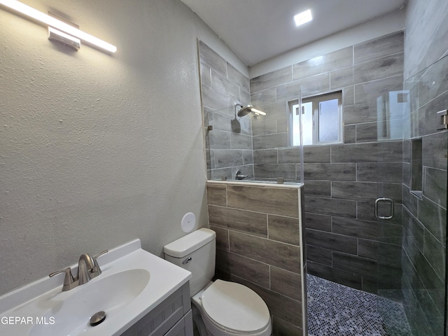 bathroom featuring vanity, an enclosed shower, and toilet