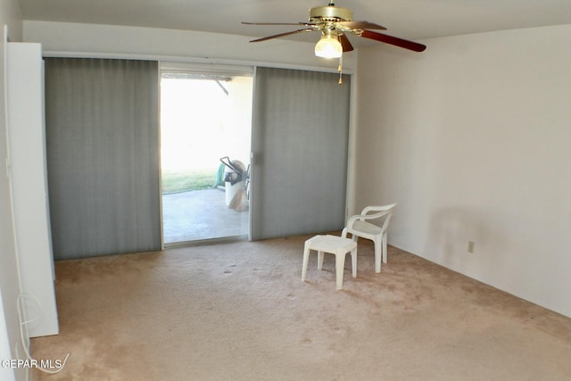 empty room featuring ceiling fan and light colored carpet